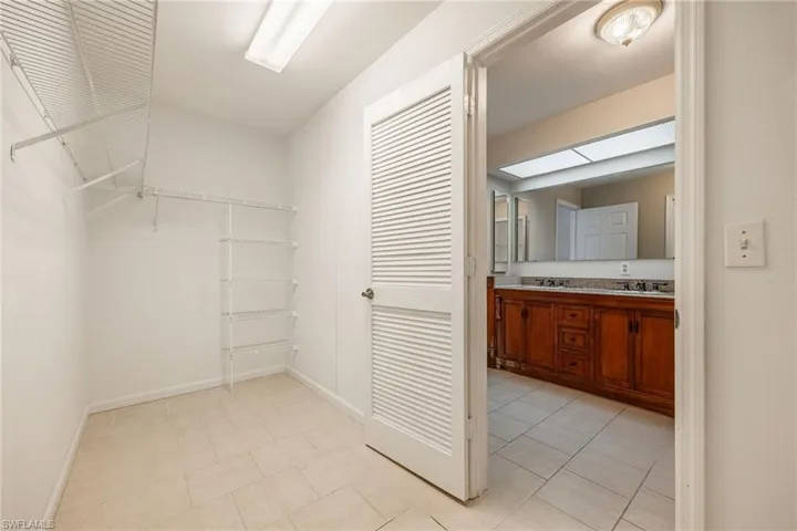 Spacious closet with a sink and light tile patterned floors