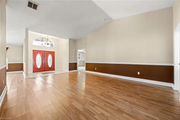 Entryway featuring visible vents, light wood-style flooring, a chandelier, and baseboards