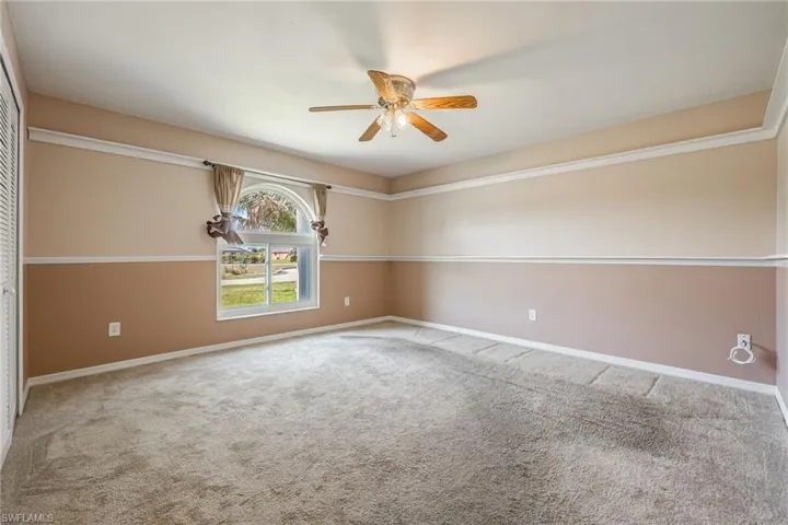 Empty room with carpet floors, baseboards, and ceiling fan