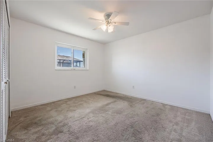 Empty room featuring baseboards, a ceiling fan, and carpet