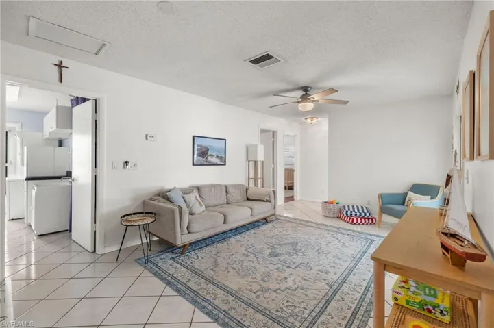 Tiled living room with a textured ceiling and ceiling fan