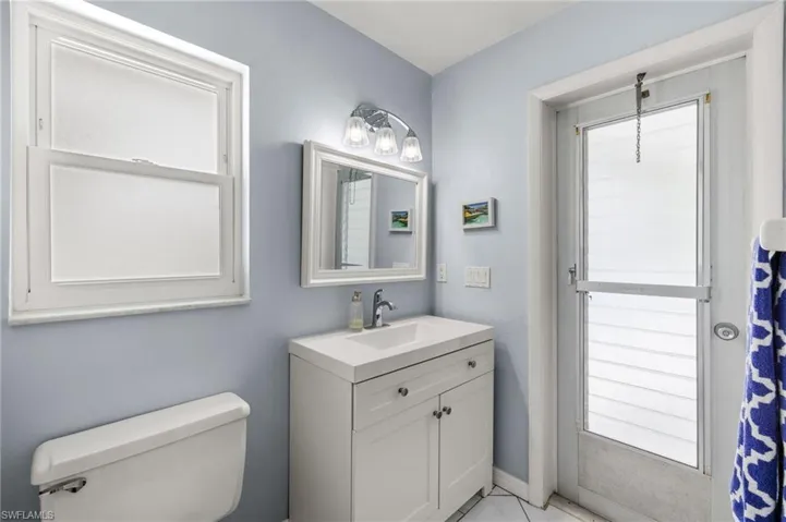 Bathroom featuring tile floors, a wealth of natural light, toilet, and vanity
