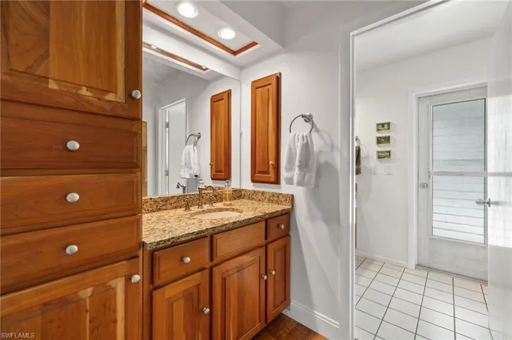 Bathroom with vanity with extensive cabinet space and tile floors