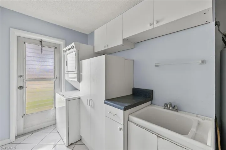 Washroom featuring light tile floors and a textured ceiling