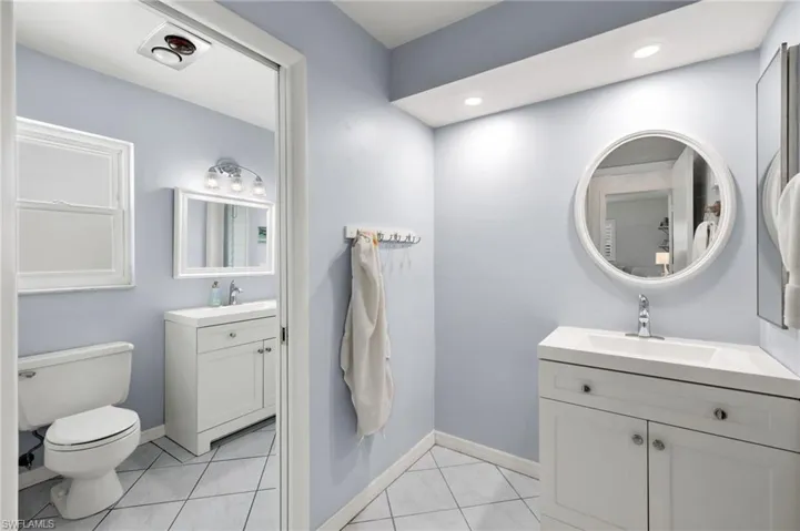 Bathroom featuring tile flooring, double sink vanity, and toilet