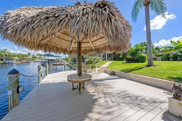 Dock area featuring a water view with intersecting canals with your very own tiki bar