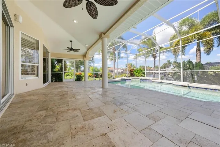 Swimming pool, spa featuring ceiling fan, a patio area, a sunroom, and glass enclosure