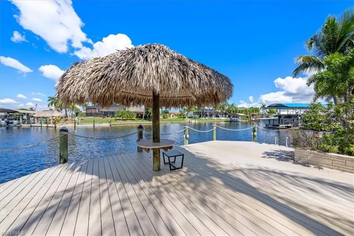 Dock area featuring a water view with intersecting canals with your very own tiki bar