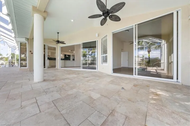 View of patio featuring ceiling fan and sliders