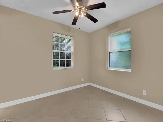 Unfurnished room with light tile patterned floors and ceiling fan