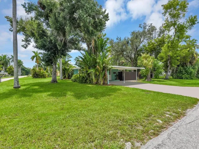 View of front of property with a carport and a front yard