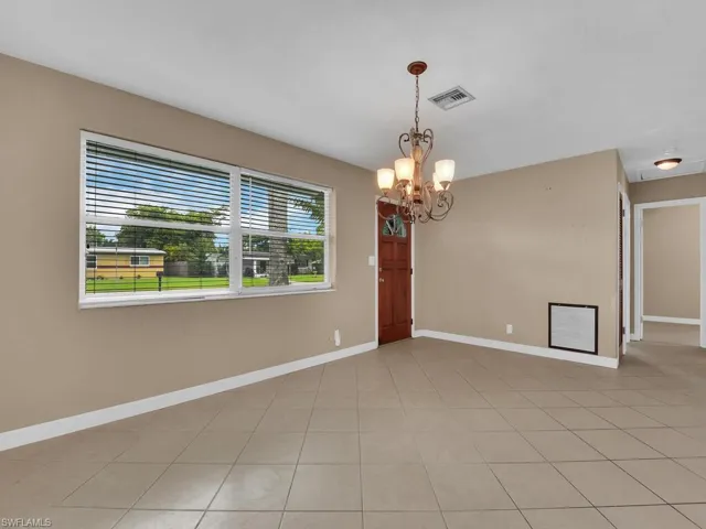 Spare room with a chandelier and light tile patterned floors