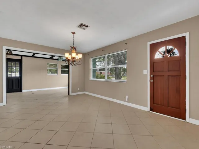 Tiled foyer entrance featuring a notable chandelier