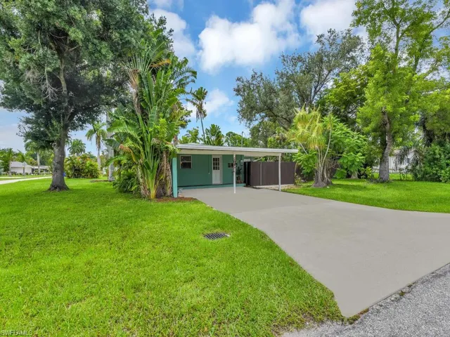 Ranch-style home featuring a carport and a front lawn