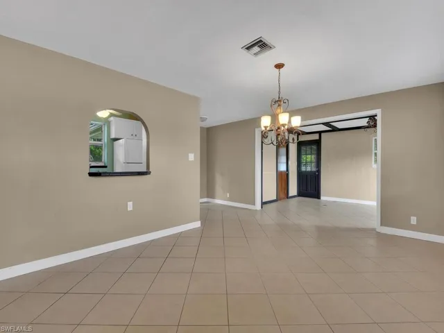 Unfurnished room with a notable chandelier and light tile patterned floors