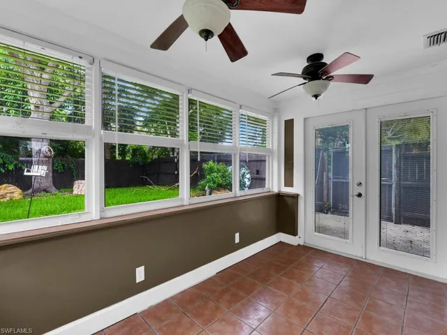 Unfurnished sunroom with french doors and ceiling fan