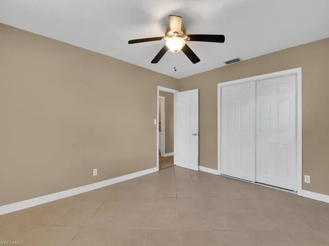 Unfurnished bedroom with a closet, ceiling fan, and light tile patterned floors