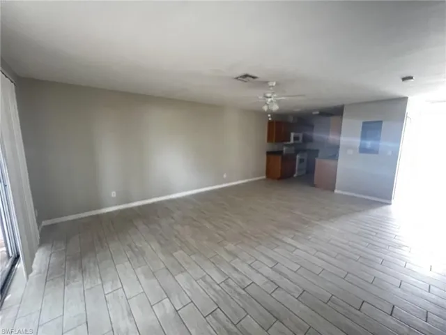 Unfurnished living room with wood finish floors and a ceiling fan