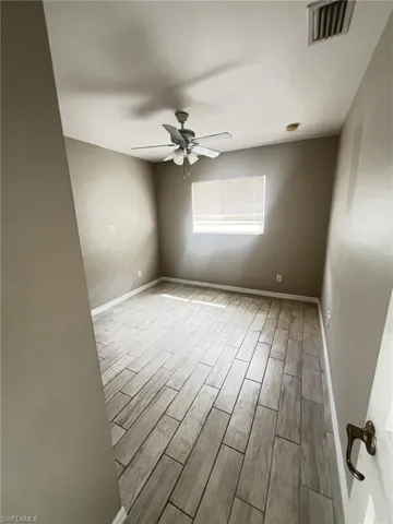 Spare room featuring wood finish floors and a ceiling fan