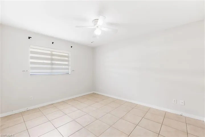 Guest bedroom with ceiling fan, and light tile patterned floors