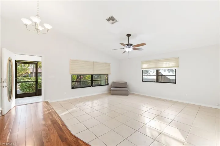 Livingroom featuring light tile patterned floors, ceiling fan, a wealth of natural light, and high vaulted ceiling