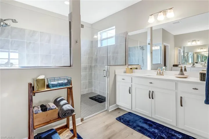 Bathroom featuring vanity, wood-type flooring, and walk in shower