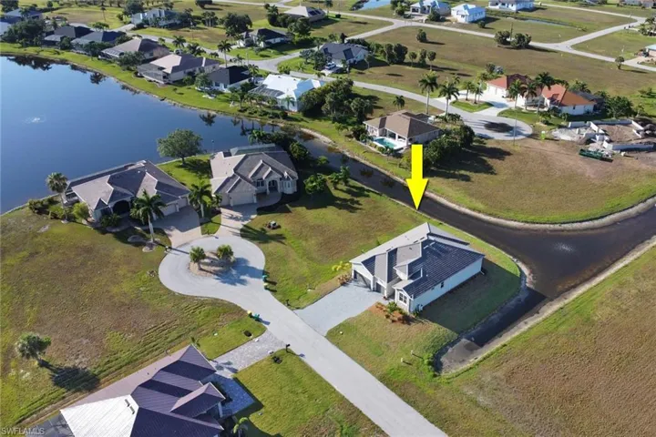 Birds eye view of property with a water view