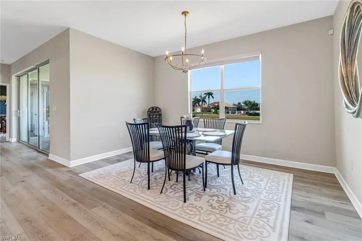 Dining space with an inviting chandelier and light hardwood / wood-style flooring