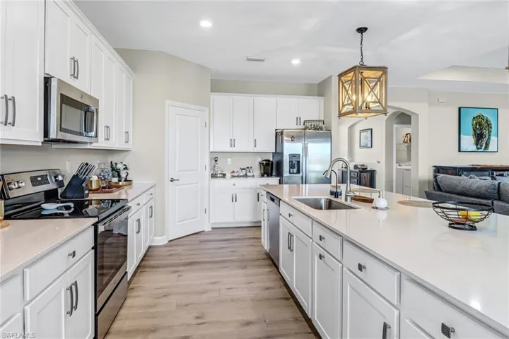 Kitchen featuring sink, light hardwood / wood-style flooring, stainless steel appliances, and white cabinets