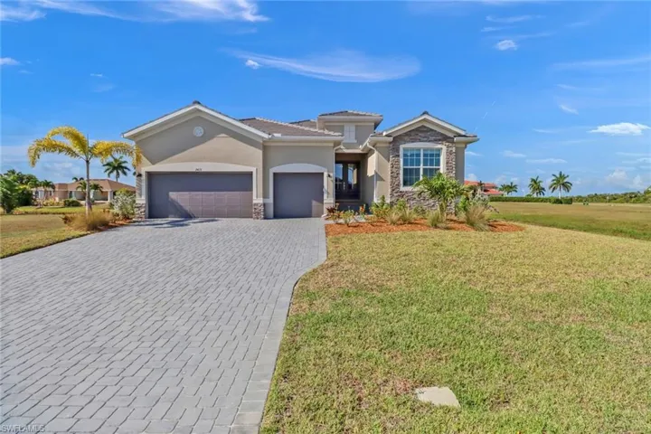 View of front of property with a garage and a front lawn