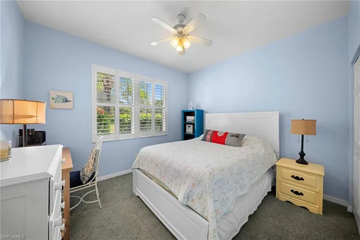 Bedroom featuring dark carpet, a ceiling fan, and a closet