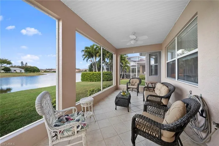 Sunroom featuring ceiling fan and a water view