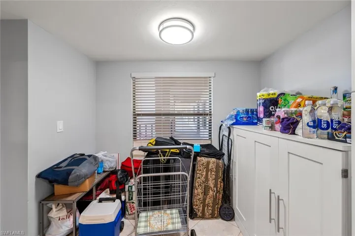 Clothes washing area featuring light tile patterned flooring and washing machine and clothes dryer