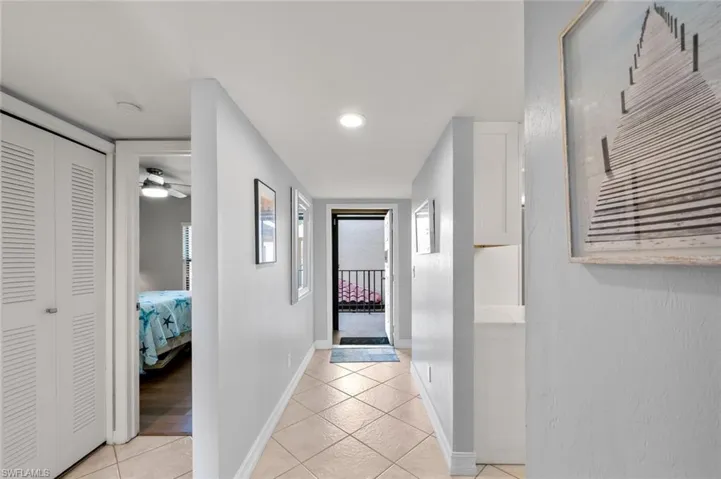 Hallway featuring light tile patterned floors and plenty of natural light