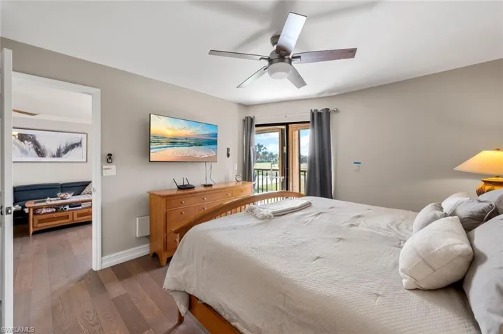 Bedroom featuring access to outside, dark hardwood / wood-style floors, and ceiling fan