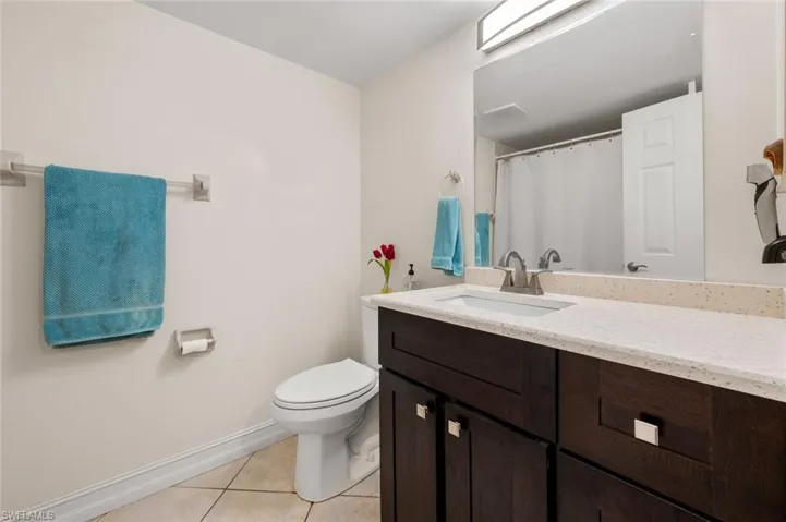 Bathroom featuring tile patterned flooring, vanity, and toilet