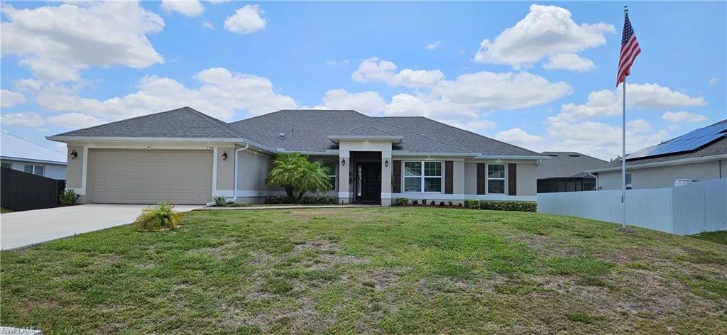 View of front of home with a garage, concrete driveway, and stucco siding