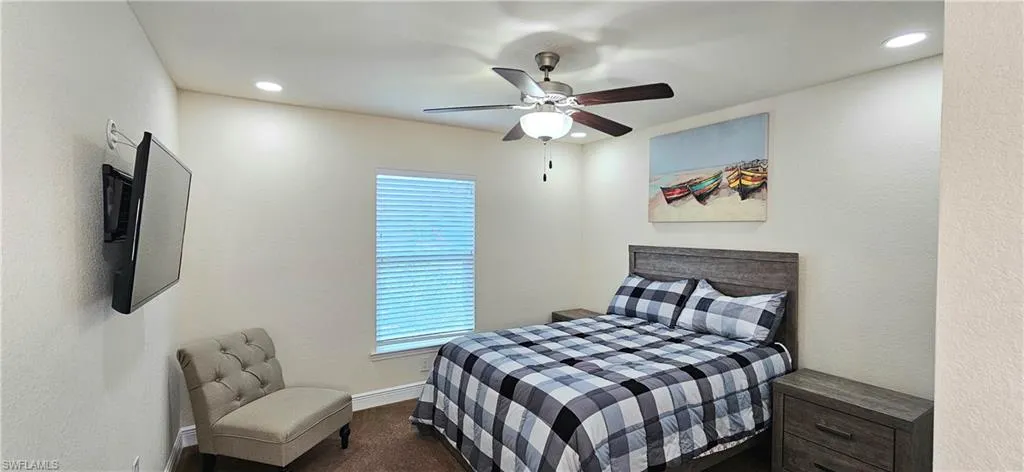 Bedroom featuring multiple windows, carpet, baseboards, recessed lighting, and ceiling fan