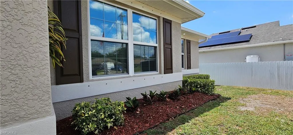 View of property exterior featuring fence and stucco siding