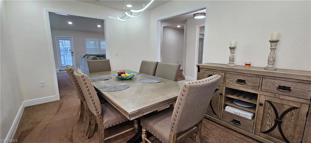 Carpeted dining area featuring baseboards and recessed lighting