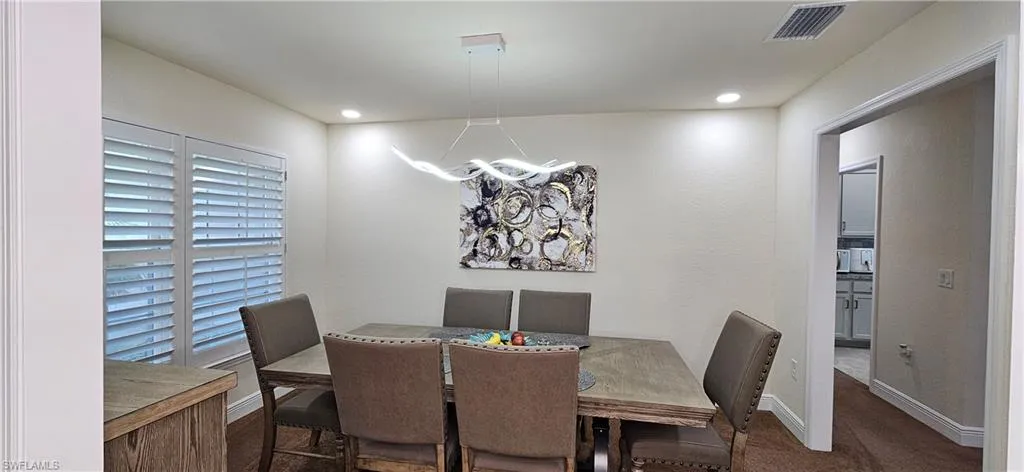 Dining room with a chandelier, baseboards, carpet flooring, and recessed lighting