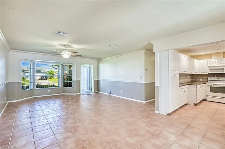 Unfurnished living room featuring ornamental molding, light tile patterned floors, and ceiling fan