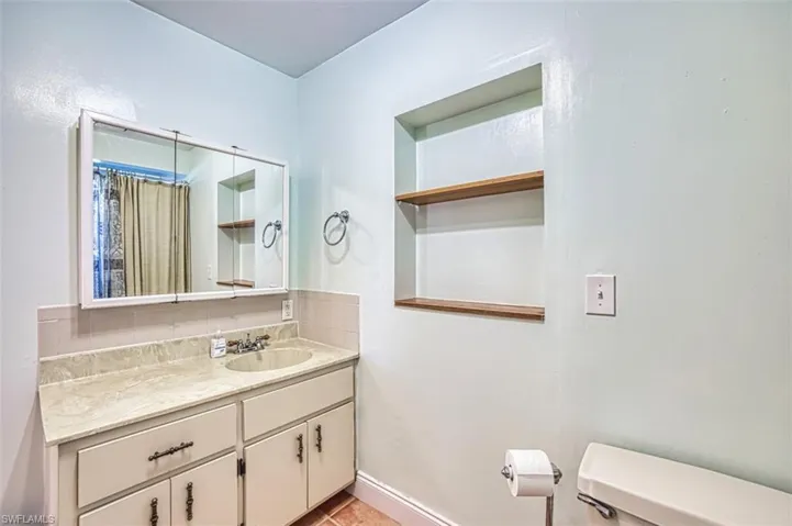 Bathroom featuring vanity and decorative backsplash