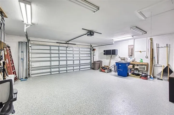Garage featuring a garage door opener and electric panel