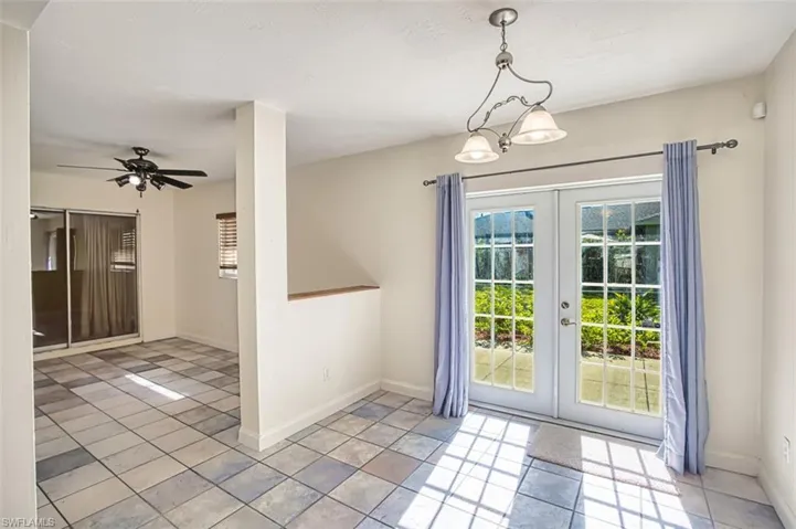 Unfurnished dining area featuring french doors, a ceiling fan, and tile patterned flooring