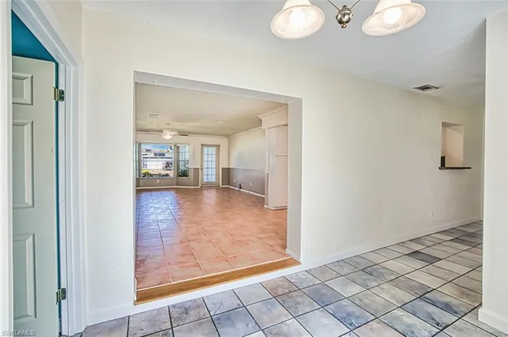 Hall with baseboards and tile patterned flooring