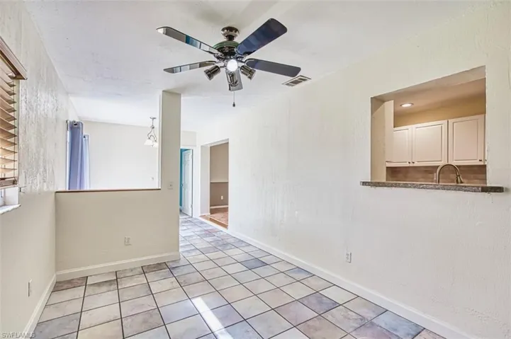 Empty room featuring ceiling fan and light tile patterned floors