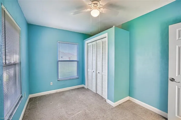 Unfurnished bedroom featuring a closet, carpet, and a ceiling fan