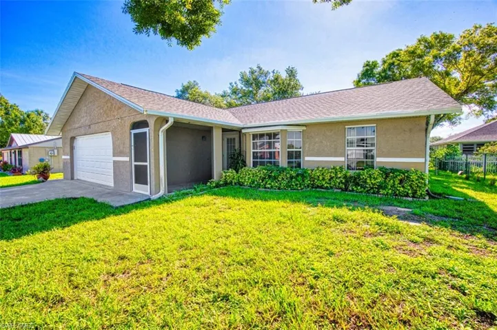 Ranch-style home with stucco siding, an attached garage, and asphalt driveway