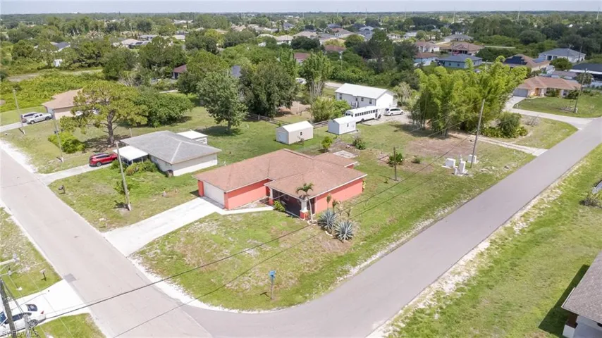 Corner lot home featuring a coral exterior, attached garage, and a concrete driveway